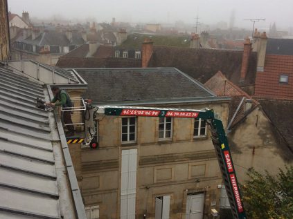 grue sur une toiture en zinc