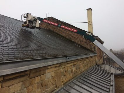 grue et nacelle sur une toiture en ardoise